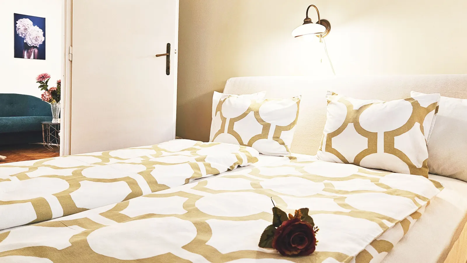 Double bed with fresh linen and a single rose